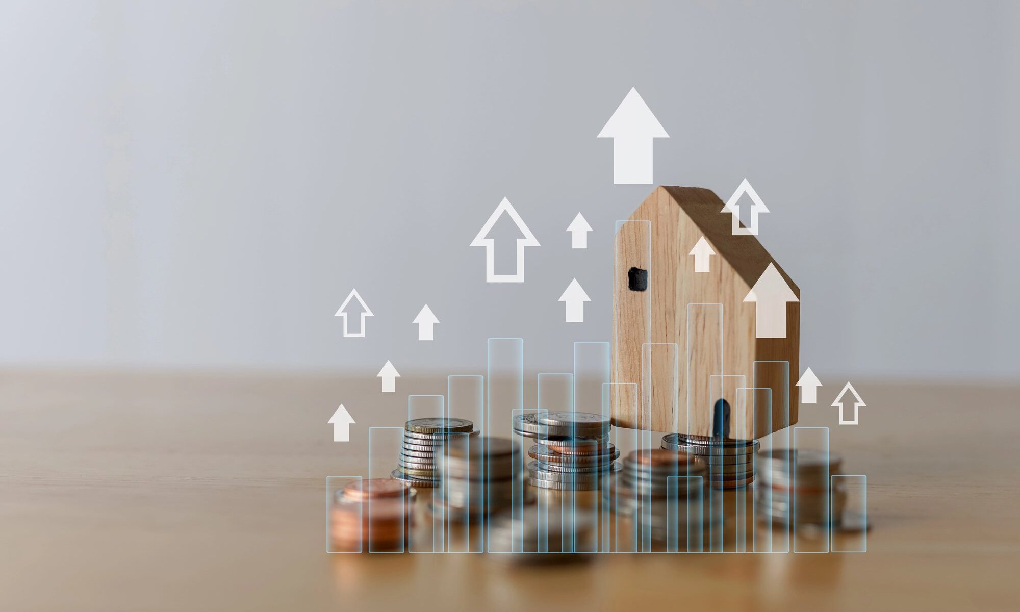 Hausmodell auf gestapelten Münzen mit aufsteigenden Pfeilen und Diagramm – Symbolbild für Liegenschaftszins und Immobilienrendite