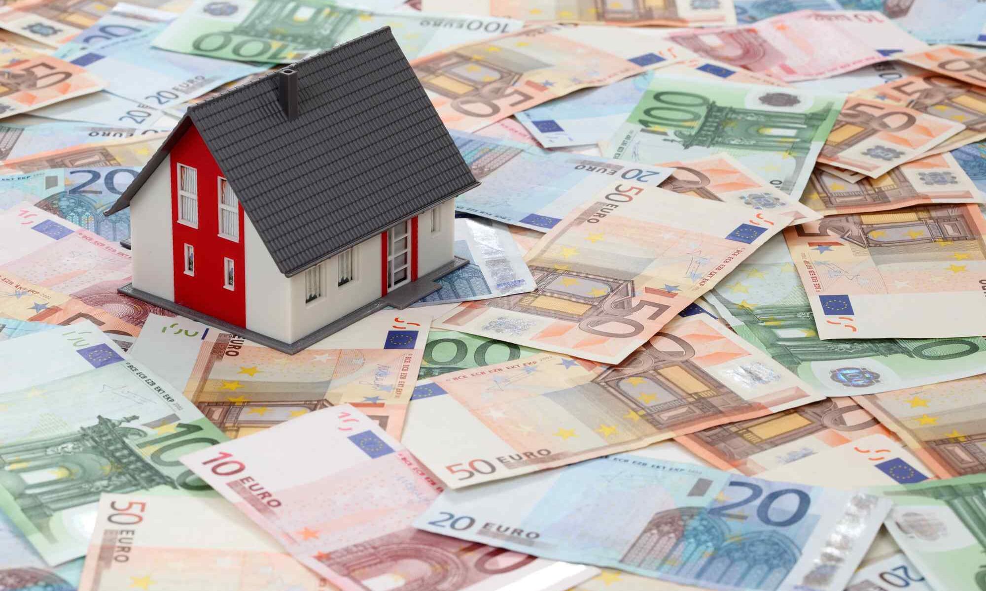 Modellhaus auf Euro-Banknoten – Symbolbild für Immobilienfinanzierung, Modernisierungsdarlehen oder Finanzierung von Renovierung und energetischer Sanierung.