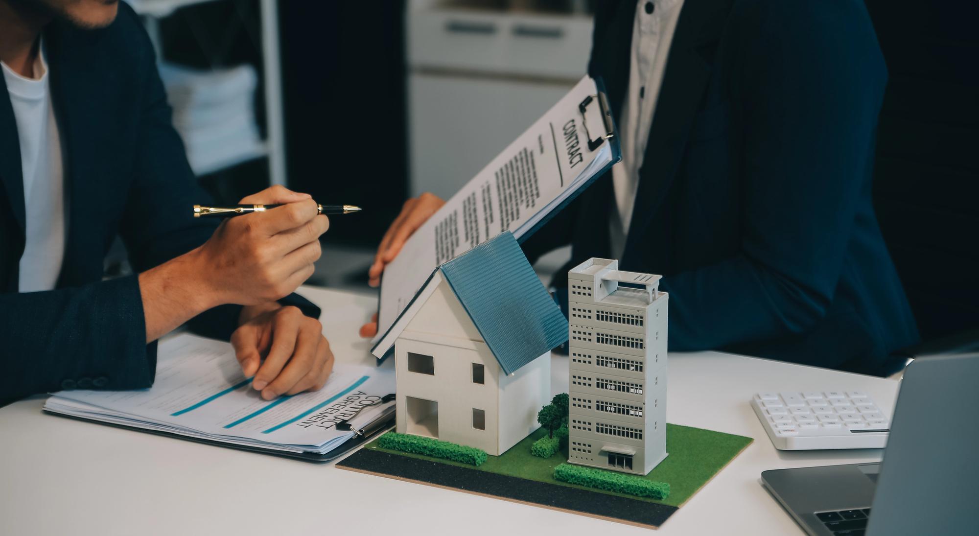 Berater analysiert Immobilienunterlagen und Gebaeudemodell zur Erstellung eines Restnutzungsdauergutachtens fuer steuerliche Abschreibungen und Immobilienbewertung.